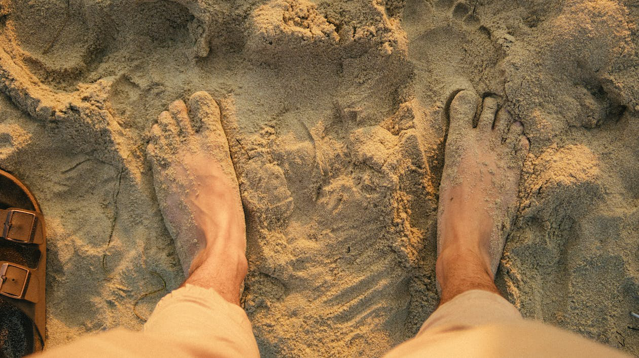 Feet Buried In Beach Sand